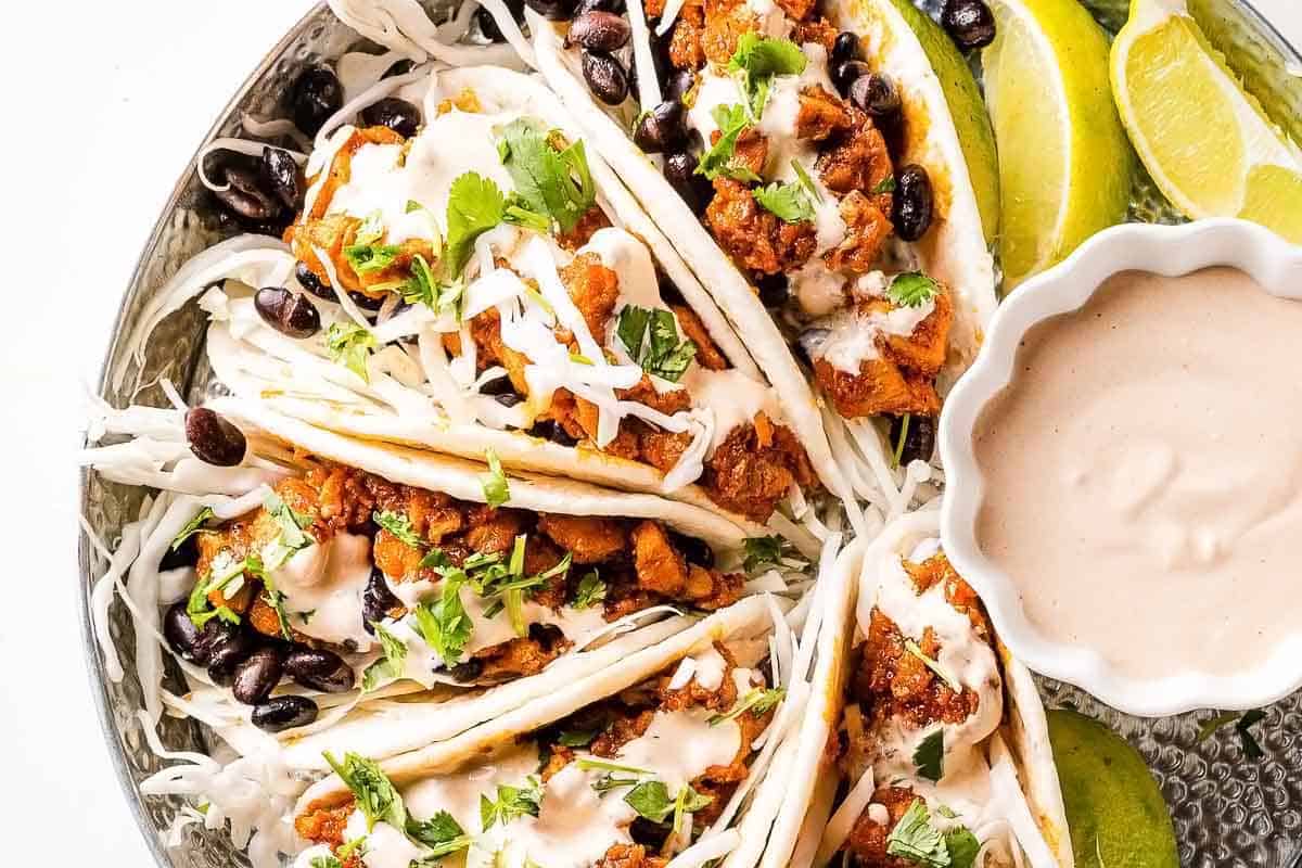 chipotle chicken tacos in tray with sauce on the side