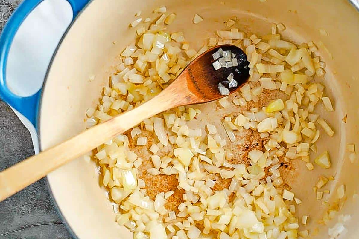 onions cooked in pot with wooden spoon