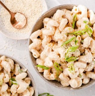 tahini pasta in two bowls with sesame seeds on the side