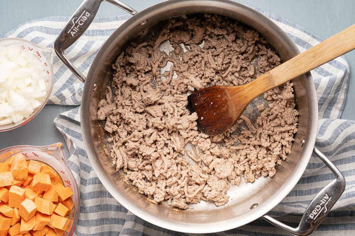 ground turkey browned in pot with wooden spoon