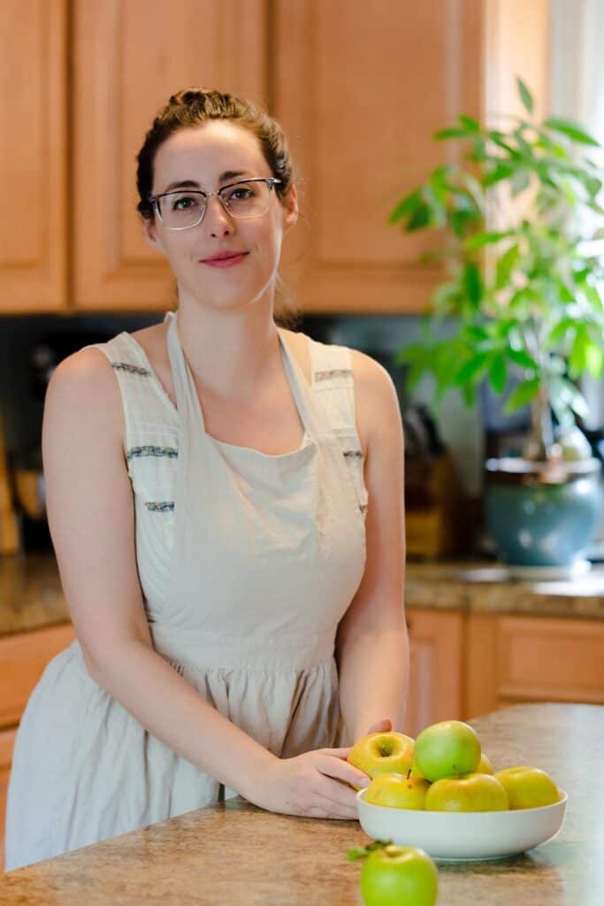 blog author Kate in kitchen with bowl of apples