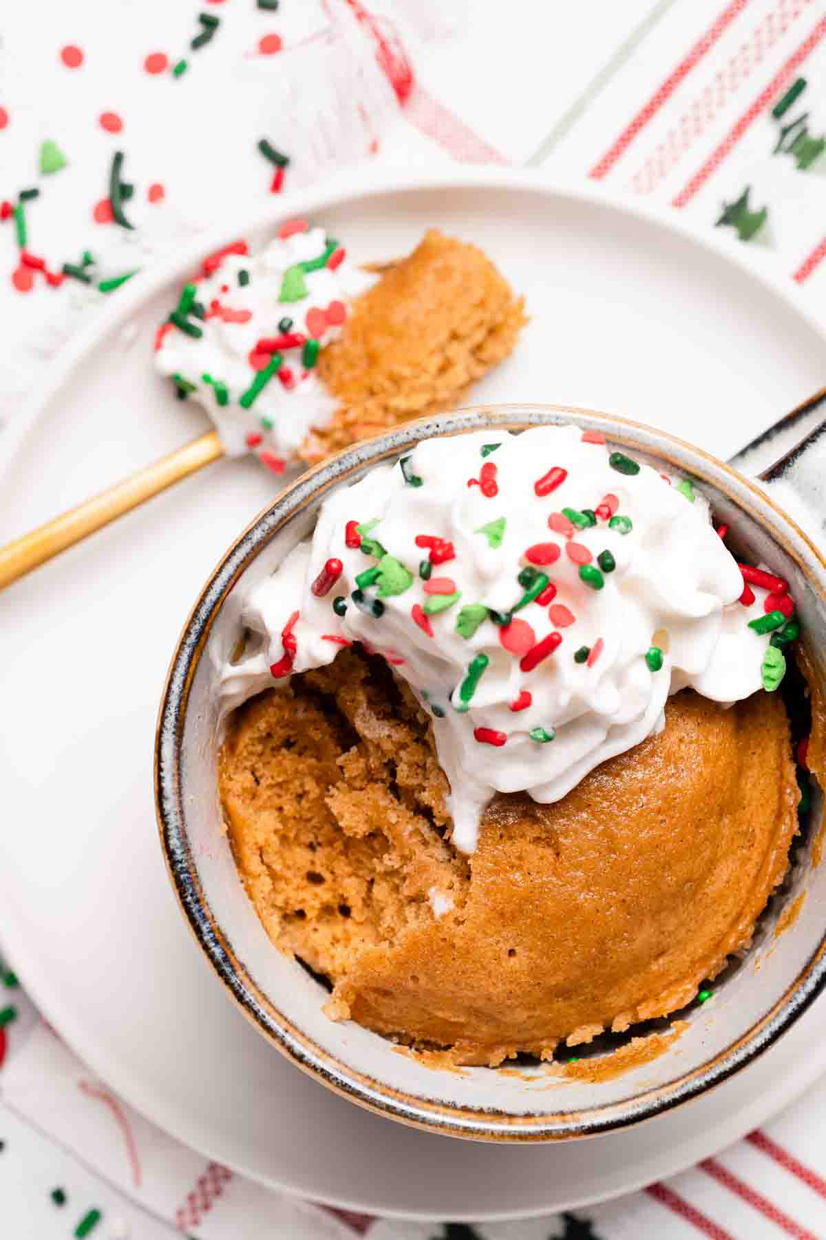 gingerbread mug cake with scoop taken out and spoon with cake on it on the side