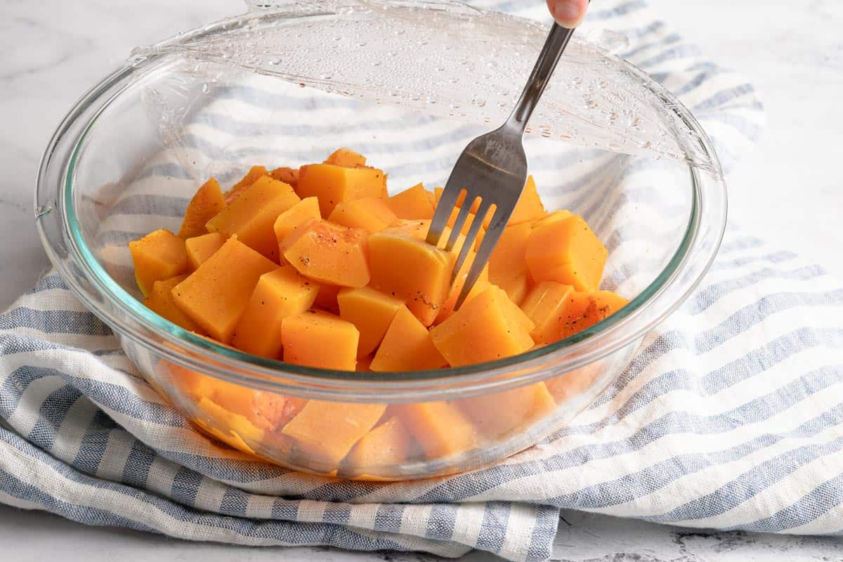 fork spearing cooked chunk of butternut squash in bowl
