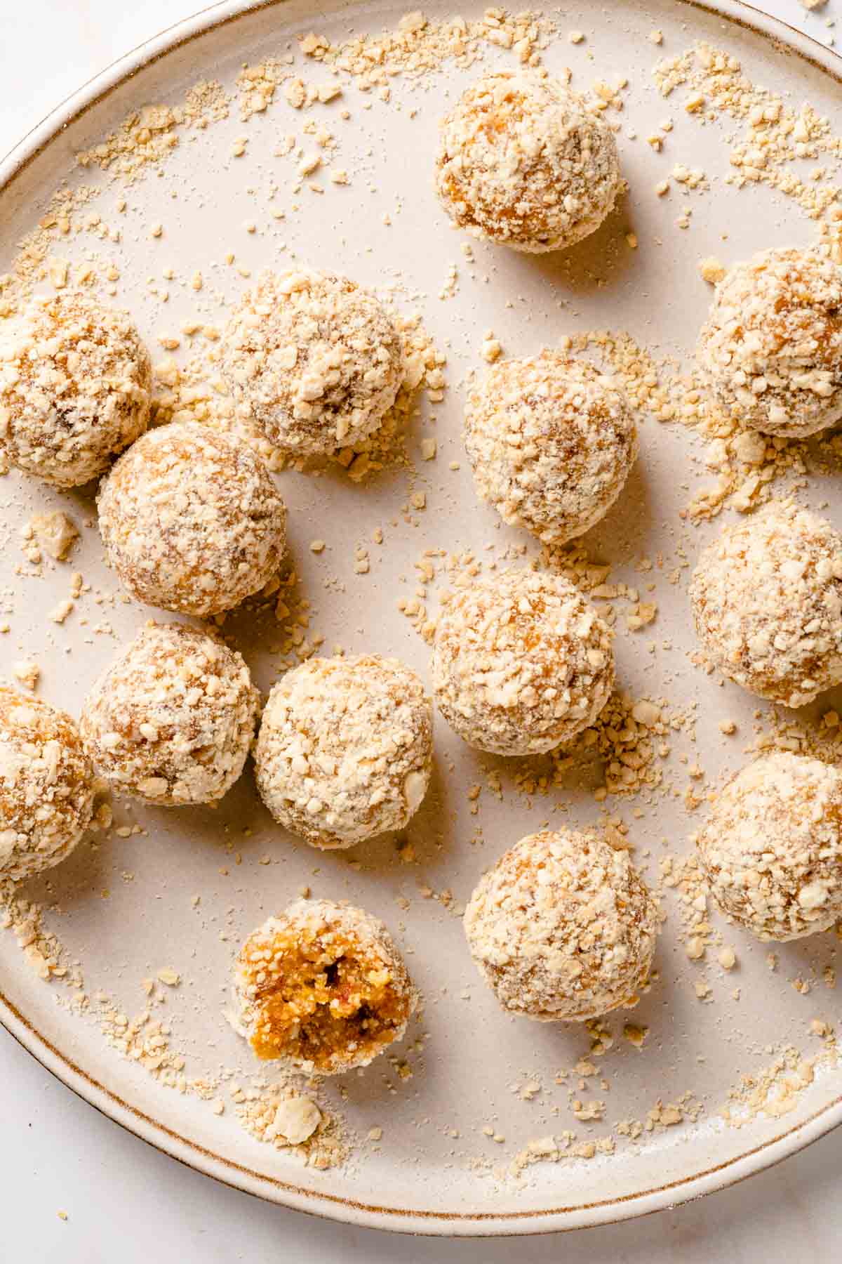 bliss balls on plate with chopped cashews