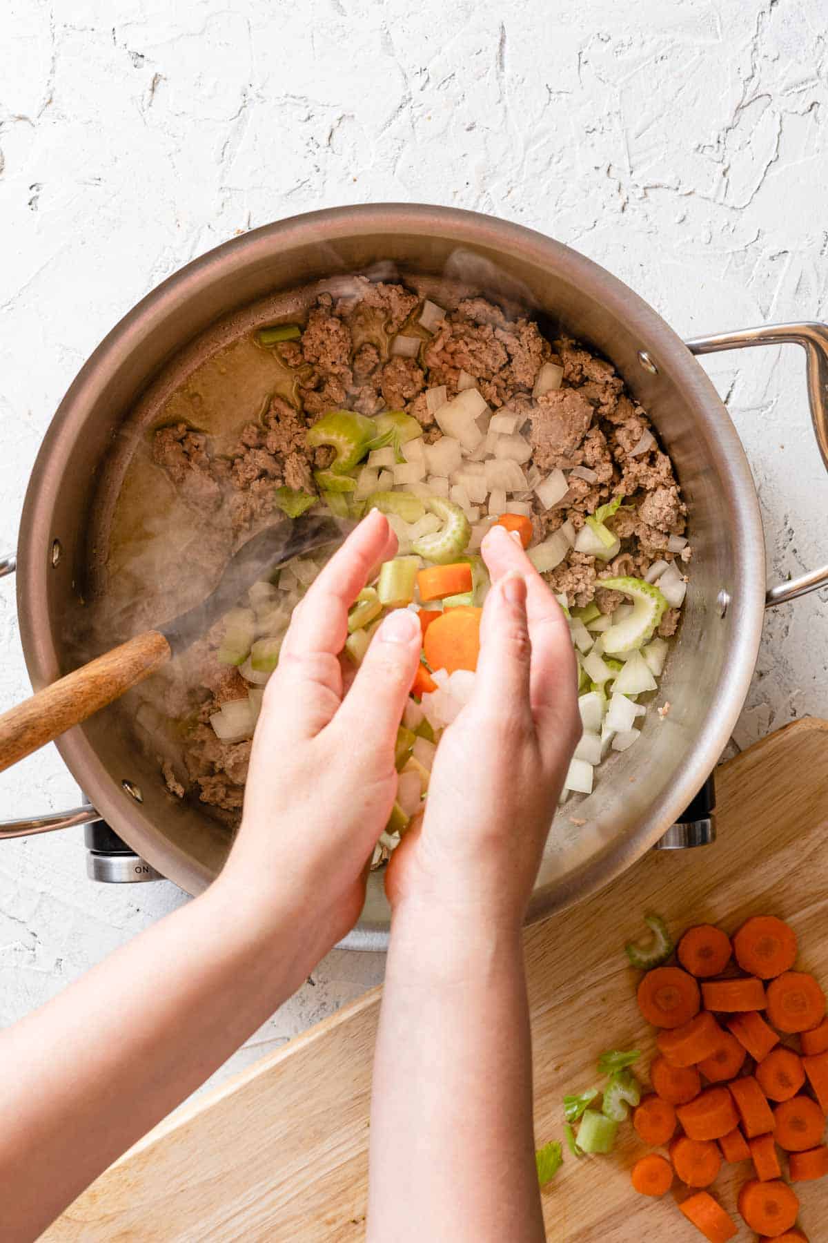 vegetables being added to soup pot
