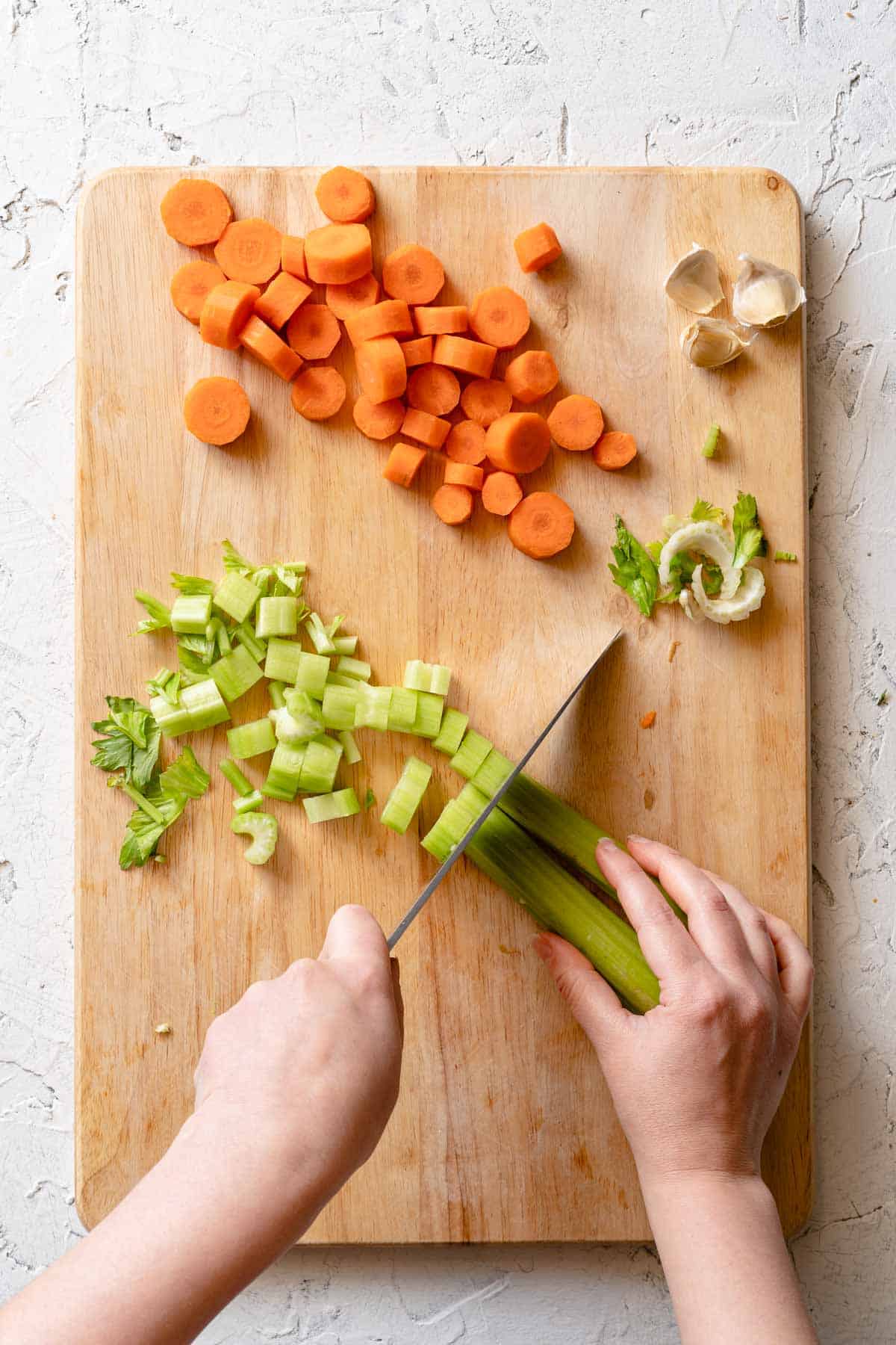 celery being sliced on cutting board