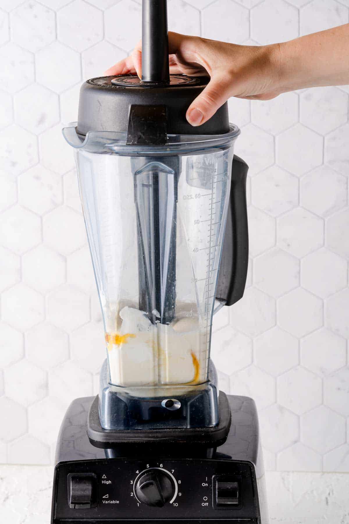 banana, milk, yogurt and honey being blended in blender