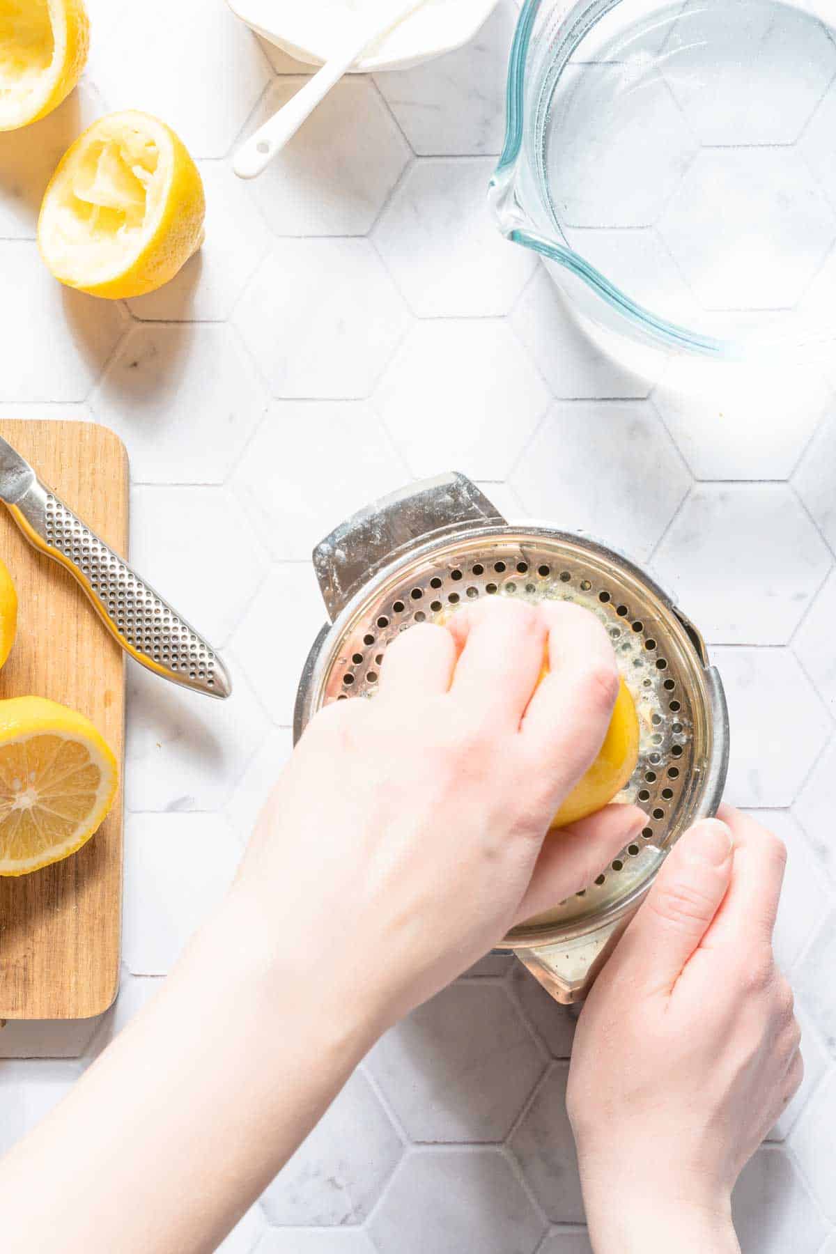 lemon being juiced with metal citrus juicer.