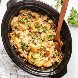 stuffing in crock pot with wooden spoon.