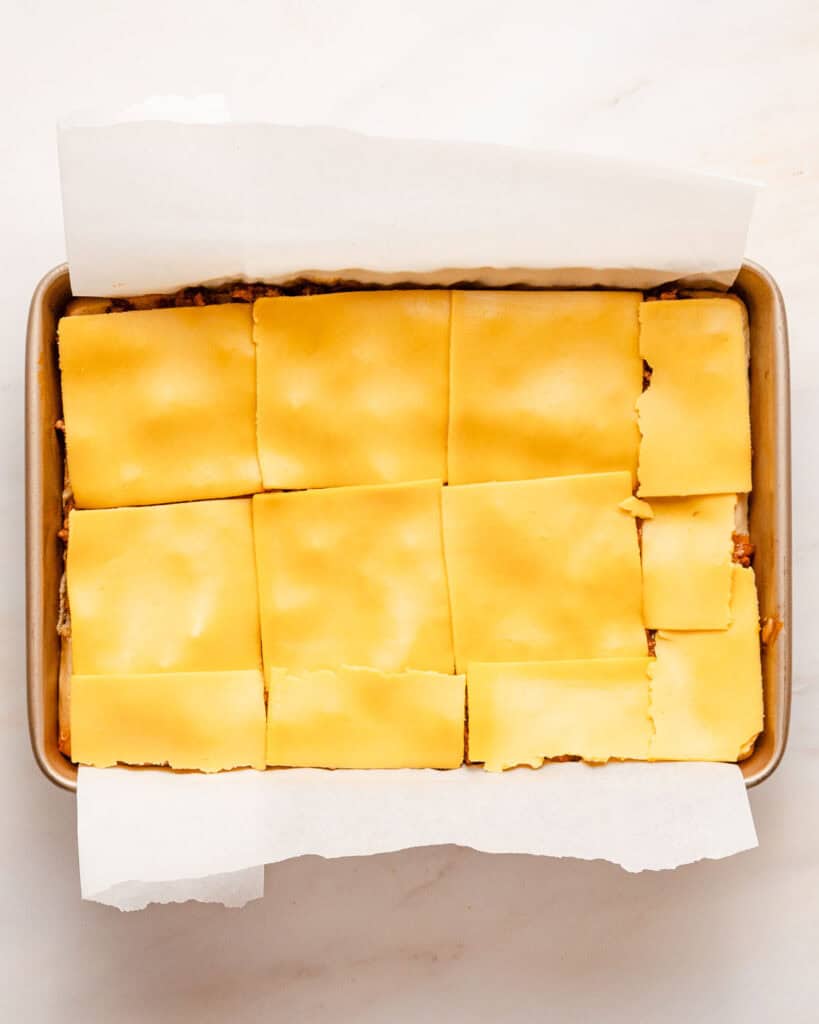 cheese slices on top of sloppy joe filling in pan.