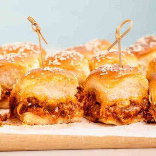 sloppy joe sliders with wooden toothpicks on cutting board.