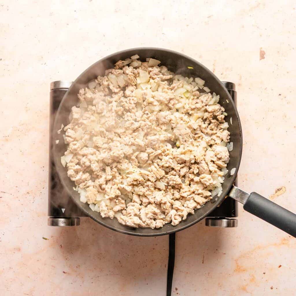 ground chicken and onion cooking in a pan.