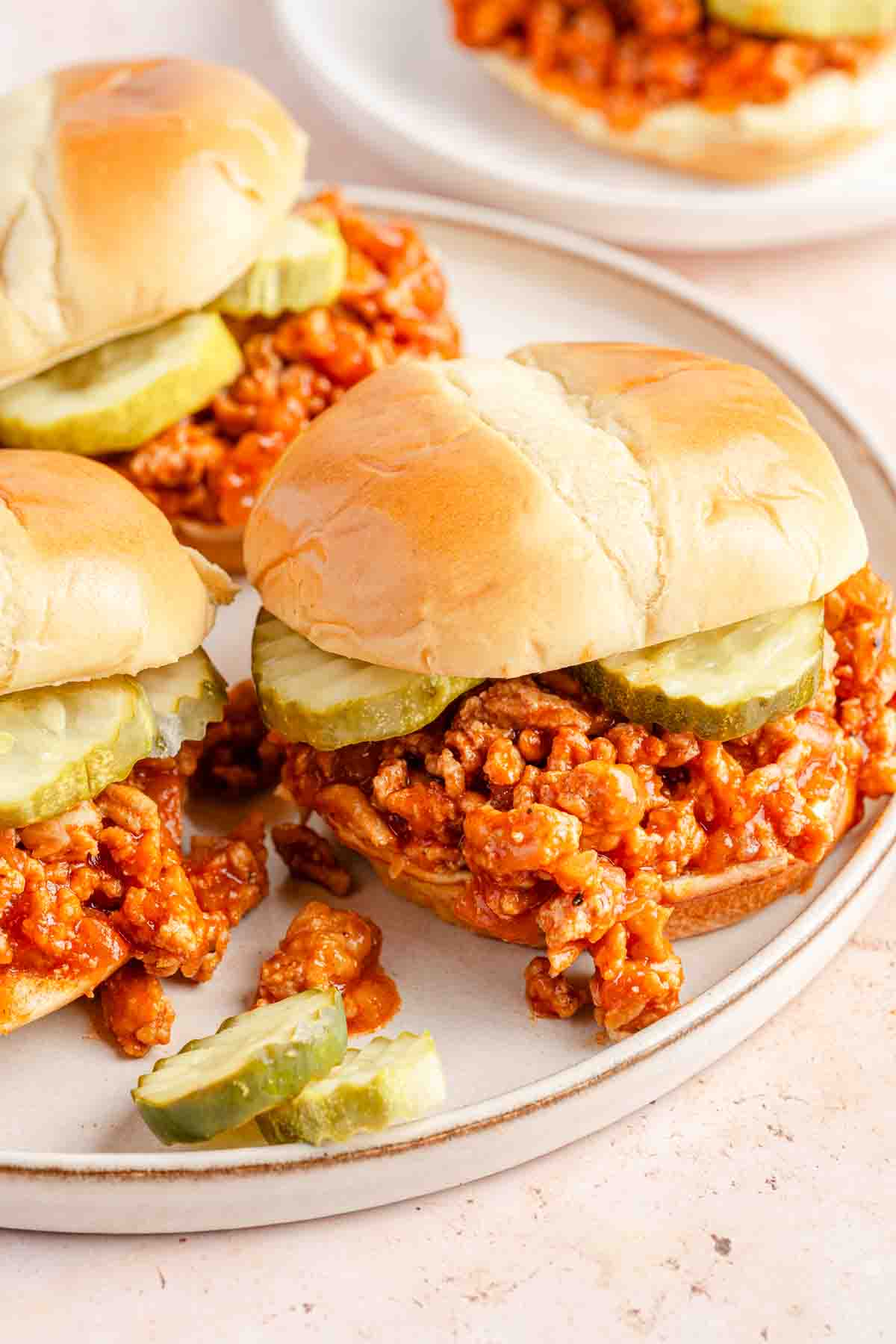 chicken sloppy joes with pickles on plate.