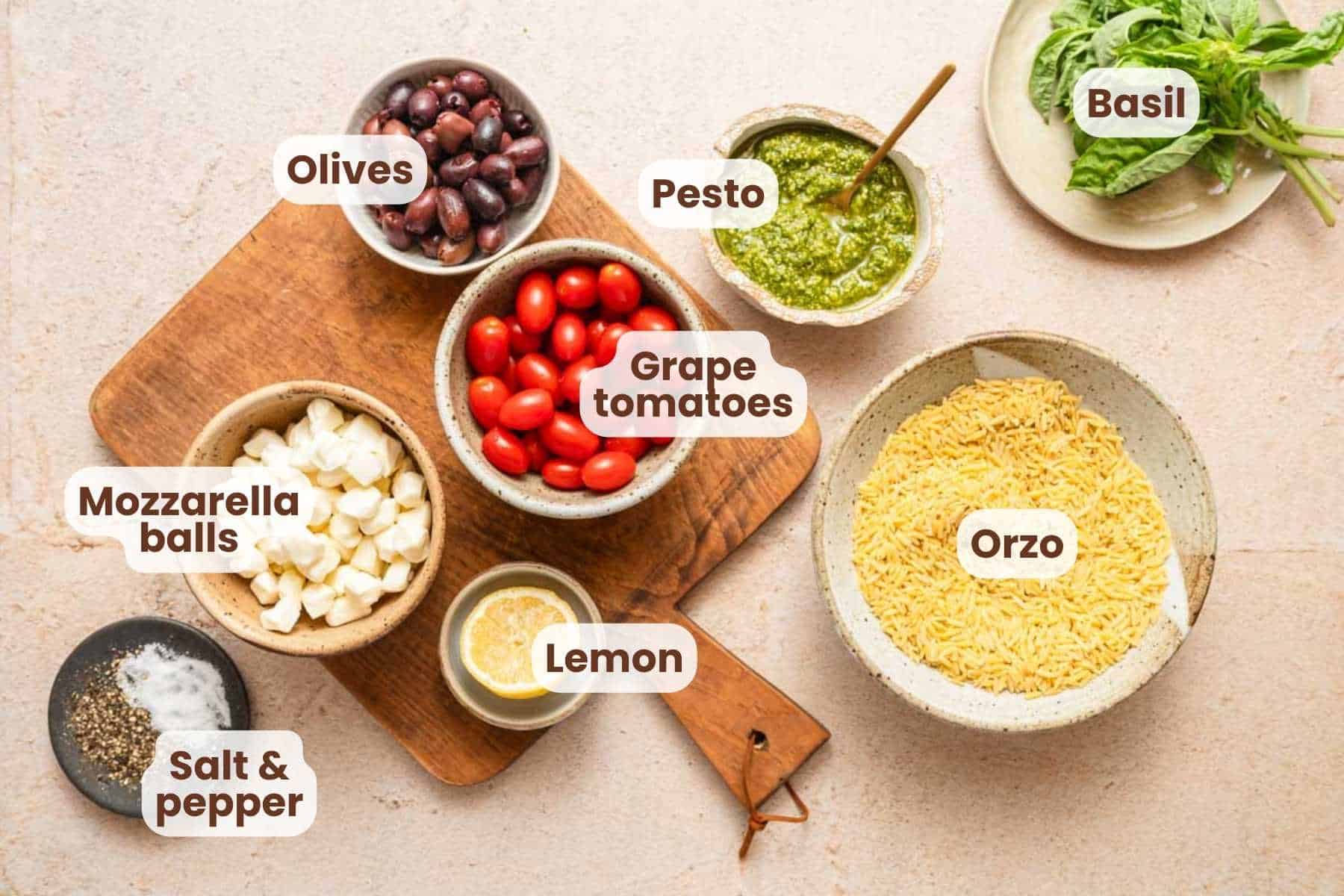 ingredients for orzo pasta salad with pesto with text labels.