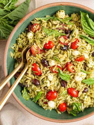 bowl of orzo pesto pasta salad with basil garnish.