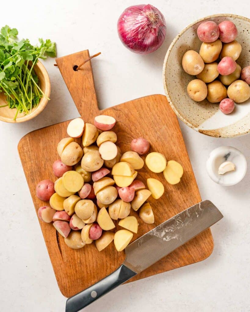 baby potatoes cut in half on cutting board.