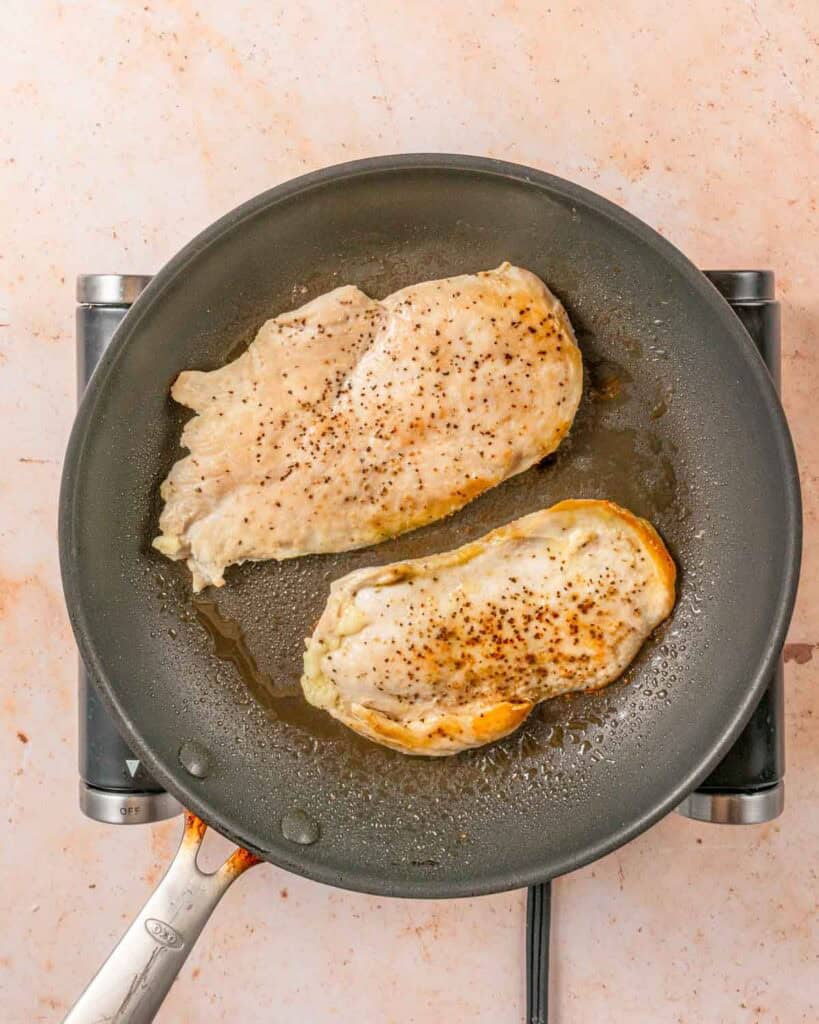 cooked chicken breasts in skillet.