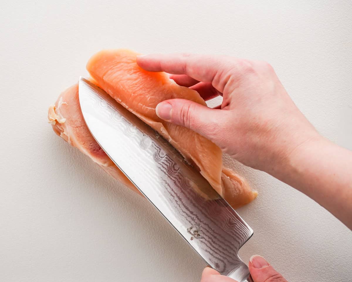 chicken breast being sliced horizontally.