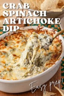casserole dish of crab spinach artichoke dip with cheesy top being scooped out with a spoon.