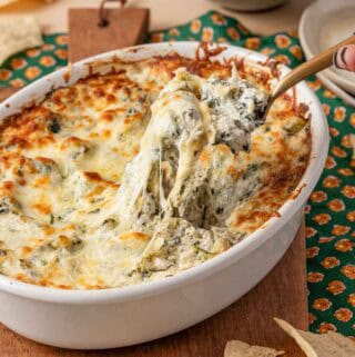 spinach artichoke crab dip being scooped.