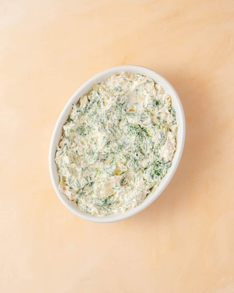 spinach artichoke dip in casserole with no cheese toopping.