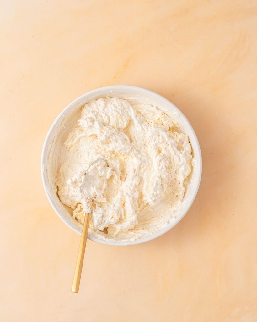 cream cheese sour cream and shredded cheese combined in a bowl.