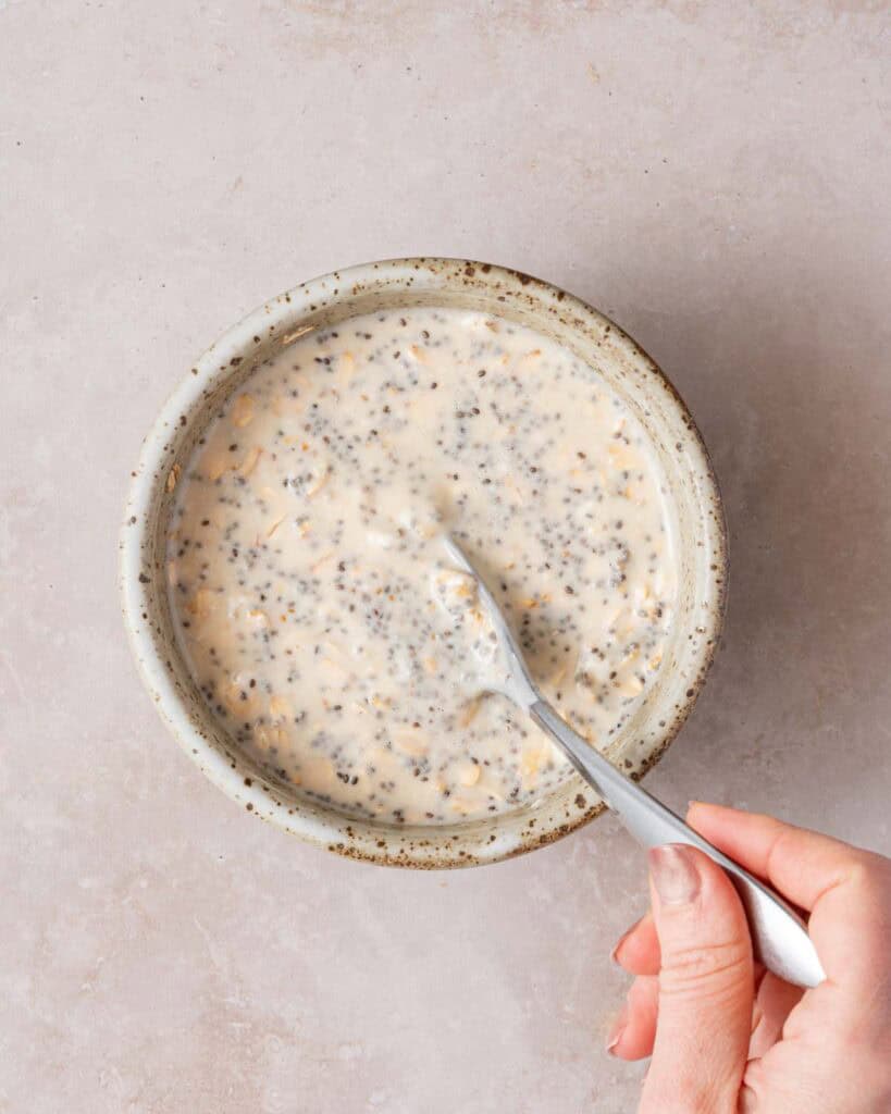 overnight oats being stirred with spoon.