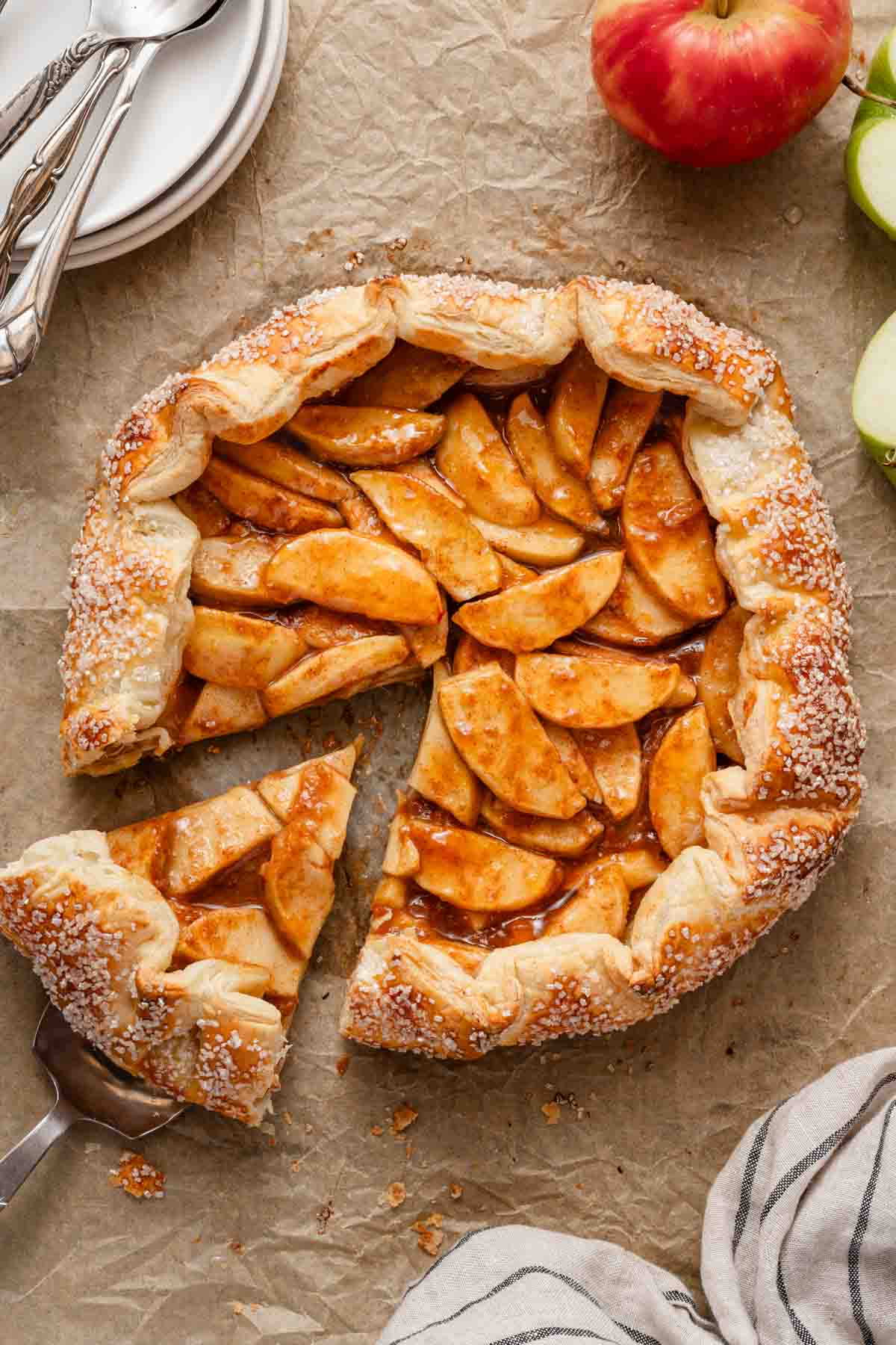 apple galette with one slice cut out with apples on the side.