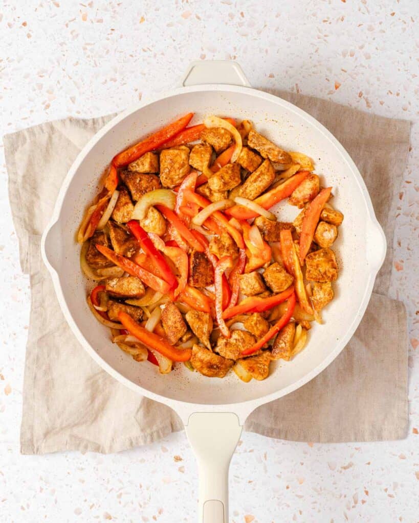 chicken bell pepper and onion in pan.