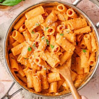 pan of creamy pasta with wooden spoon.