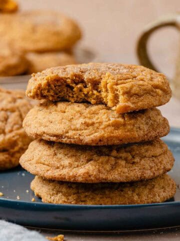 stack of pumpkin cookies on plate.