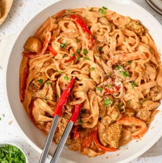 pot of creamy pasta with cajun seasoning and chunks of chicken.